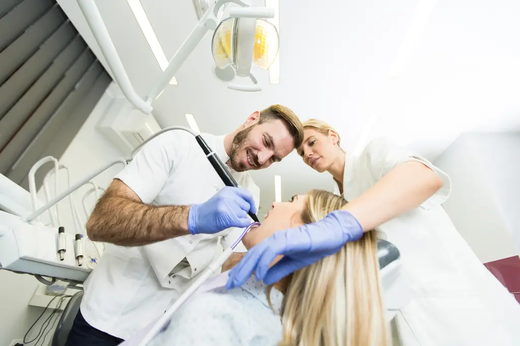 arafed woman getting her teeth examined by a dentist